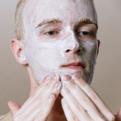 Young male using face cleanser